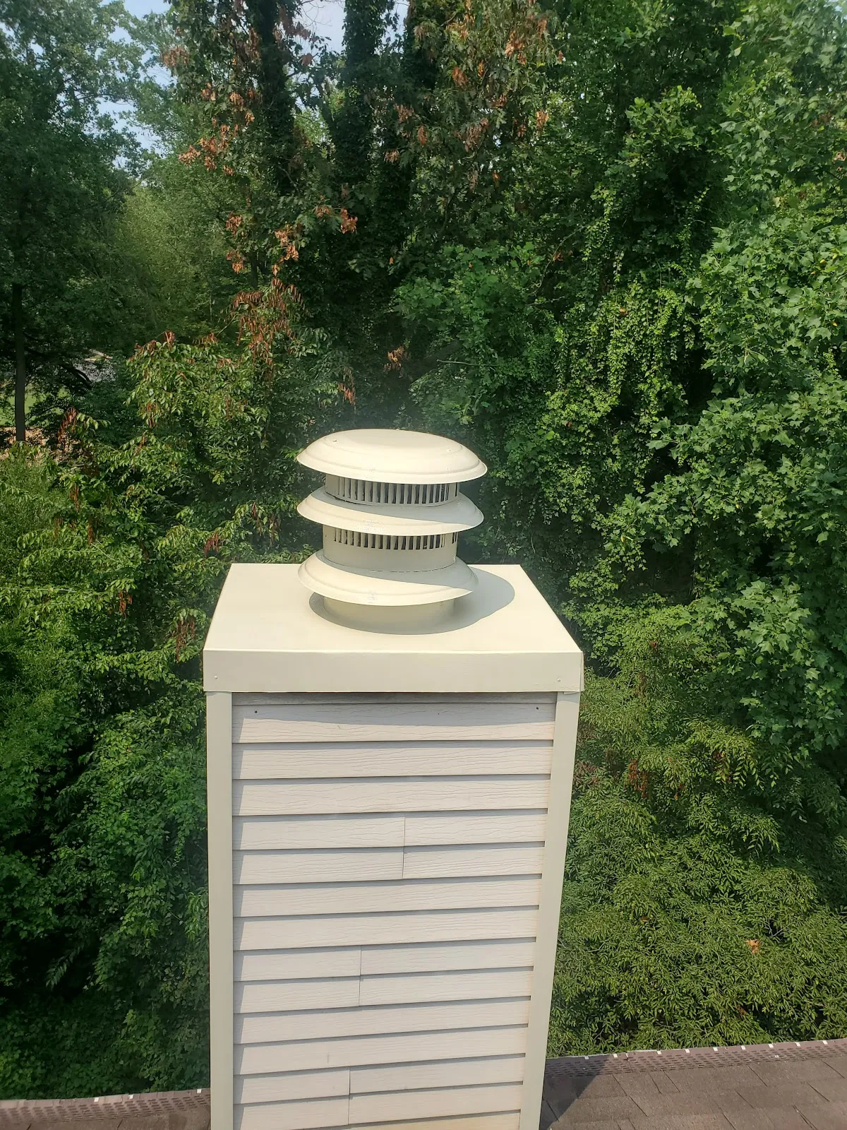 New multi-tier chimney cap on a freshly wrapped chimney chase