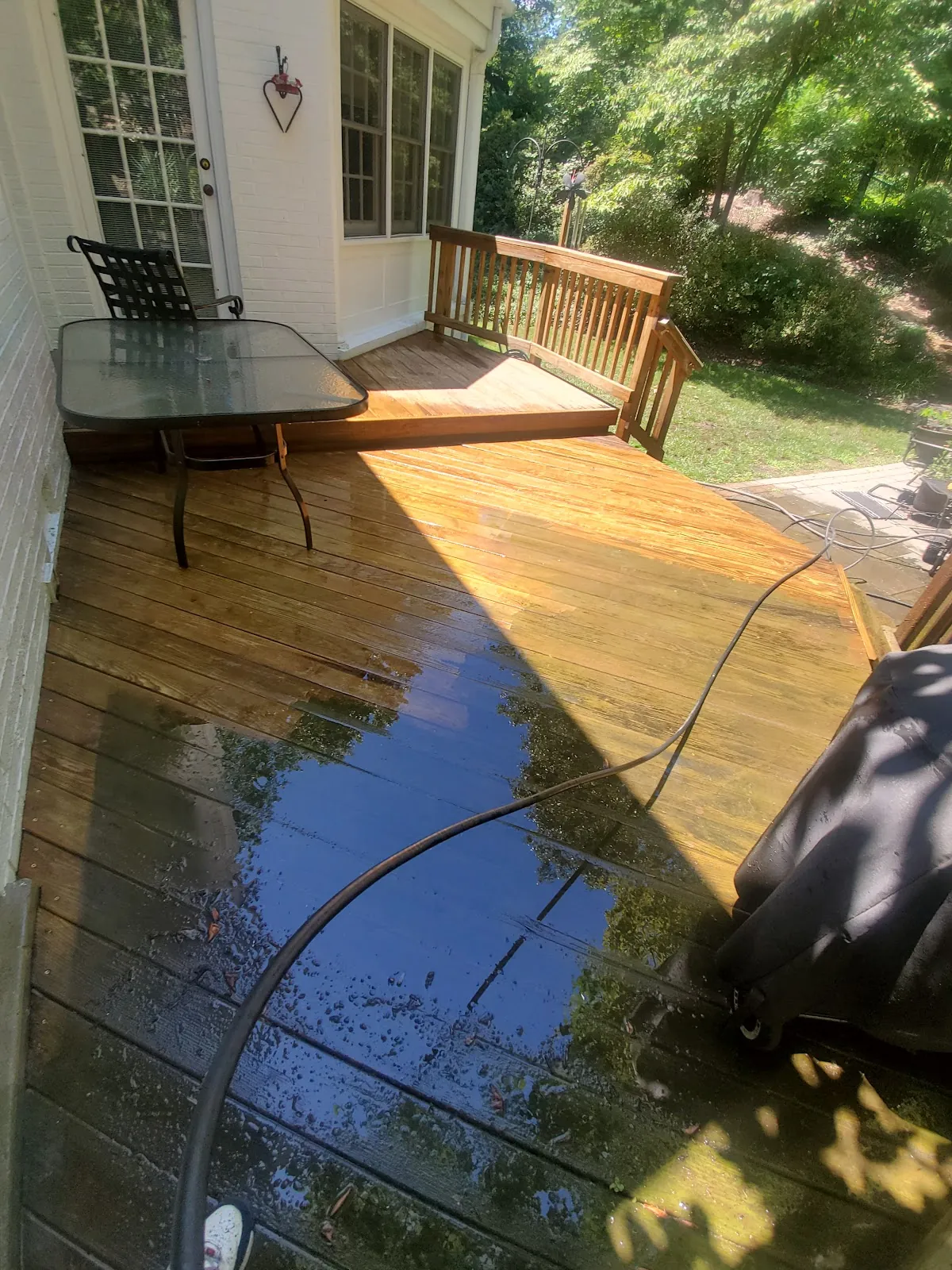 Wooden deck part-way through a pressure wash, clean boards beside dirty ones